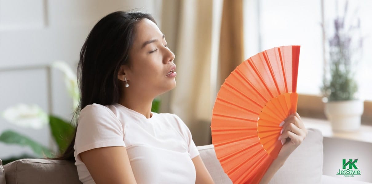 Person Holding A Fan While Reacting to Hot Temperature Indoor