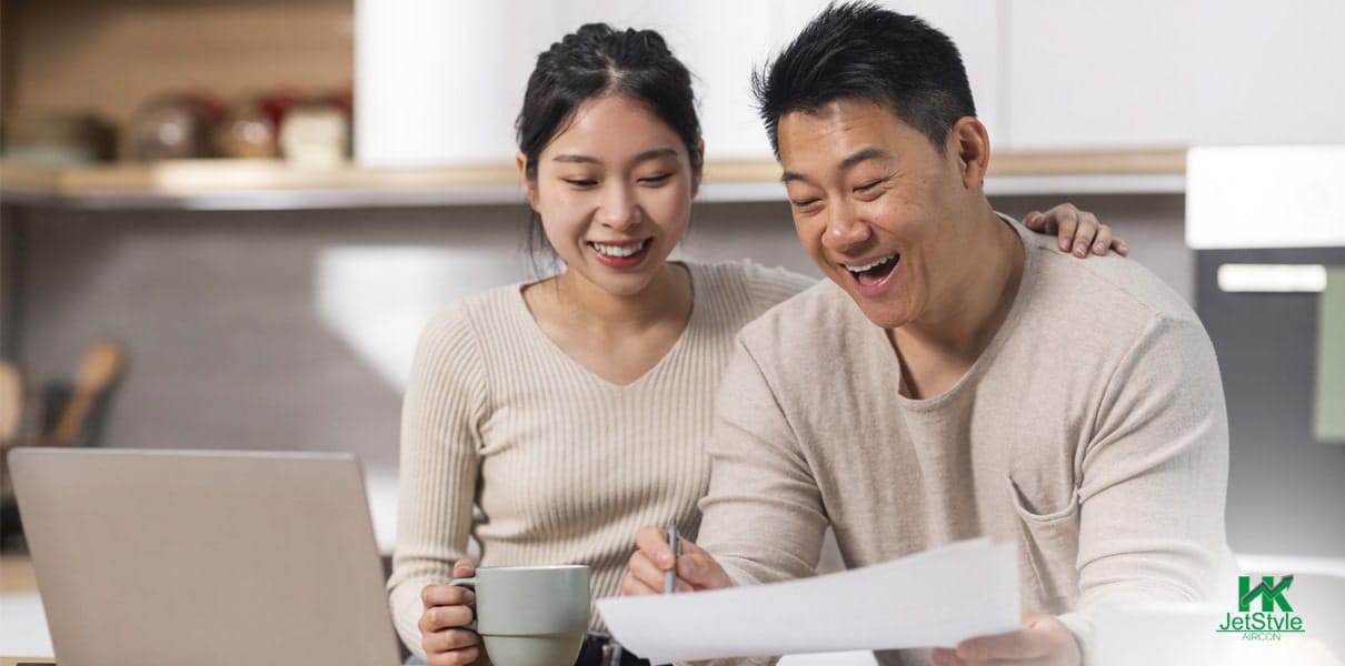 A Couple Smiling While Looking At Utility Bills
