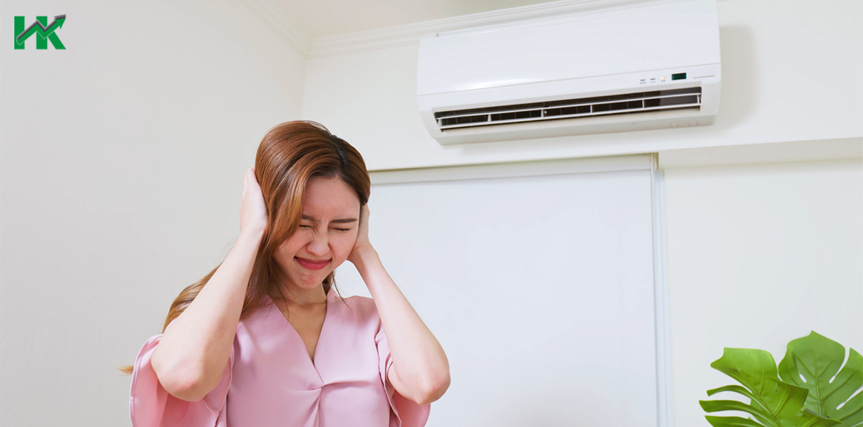 Image of a woman covering their ears from the noise generated by a noisy aircon